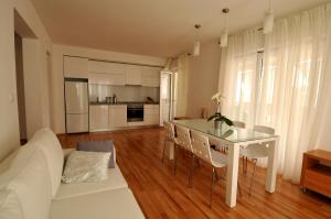 a kitchen and living room with a table and a couch at Apartments Annette - studio and two bedroom apartment with parking in Dubrovnik