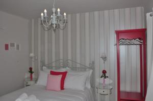 a bedroom with a bed with pink and white pillows at Sugar Home in Xylokastro