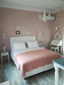 a bedroom with a large bed with a pink wall at Sugar Home in Xylokastro