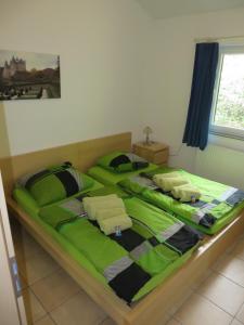 RiedenにあるFerienhaus Anneのベッドルーム1室(大型ベッド1台、緑のシーツ付)