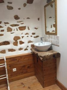 a bathroom with a sink and a wall with rocks at Chambres d'hotes des Forets in Écuras