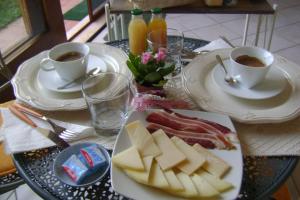 einen Tisch mit Teller mit Speisen und Tassen Kaffee in der Unterkunft Angolo Verde in Oristano