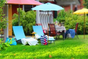 a group of chairs and tables with umbrellas in the grass at Ferienhaus Bogense in Steinbergkirche