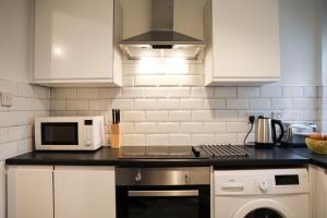 eine Küche mit Mikrowelle und Herd oberen Backofen in der Unterkunft Baron View Apartment in Paisley + 16 Fotos