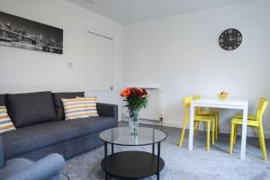 uma sala de estar com um sofá e uma mesa em Baron View Apartment em Paisley