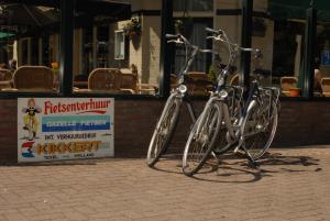 dos bicicletas estacionadas en una acera frente a un restaurante en Wapen van Exloo, en Exloo