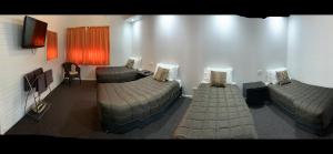 Habitación con 2 camas y TV de pantalla plana. en Orana Windmill Motel, en Gilgandra