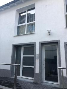a white building with two windows and a door at Apartment 4 Rent in Bochum