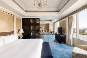 a hotel room with a large bed and a television at Pudong Shangri-La, Shanghai in Shanghai