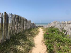 a dirt road next to a wooden fence at 2 PIECES JARDIN, ACCES DIRECT MER ET PROCHE THALASSO in Cabourg +6 photos