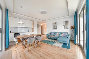 sala de estar con sofá azul y mesa en Apartamenty Sun & Snow Nadmorze, en Gdansk