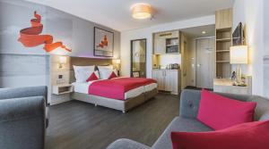 a hotel room with a bed and two chairs at Stay! Hotel Boardinghouse in Hamburg +37 photos
