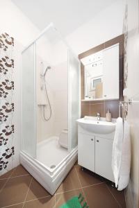 a white bathroom with a shower and a sink at Apartments Olive in Zaton
