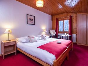 a bedroom with a large bed with a red blanket at Hotel Edelweiss in Nendaz