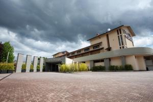 a large building with a cloudy sky in the background at Albergo Dei Laghi in Turate