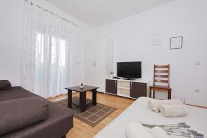 a living room with a couch and a tv at Apartments Olive in Zaton