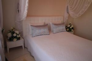 a bedroom with a white bed with two pillows at Hotel Buzuluk in Buzuluk