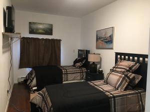 a bedroom with two beds and a television in it at Ma's Way in Anchorage