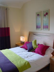 a bedroom with a bed with colorful pillows at Ardmullen in Kenmare