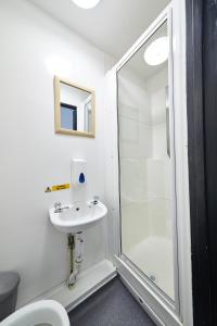 a bathroom with a shower, sink, and mirror at St Christopher's Inn Camden in London