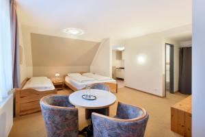 a room with a bed and a table and chairs at meinHotel in Hamburg