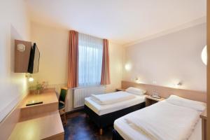 a hotel room with two beds and a desk at meinHotel in Hamburg