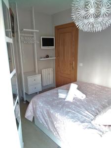 a bedroom with a bed and a chandelier at Snow in Miramar in Sierra Nevada +20 photos