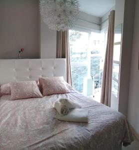 a white bed with a towel on it with a window at Snow in Miramar in Sierra Nevada