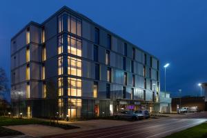 een groot zwart gebouw met auto's geparkeerd op een parkeerplaats bij Elite Athlete Centre and Hotel in Loughborough