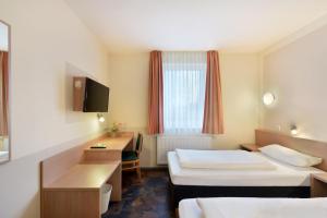 a hotel room with two beds and a desk at meinHotel in Hamburg