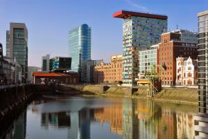 a river in a city with tall buildings at INNSiDE by Meliá Düsseldorf Hafen in Düsseldorf +32 photos