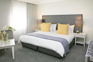 a bedroom with a large bed with yellow pillows at Hollow on the Square City Hotel in Cape Town