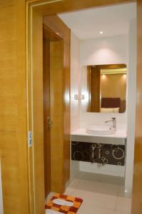 a bathroom with a sink and a mirror at Yara Suites in Buraydah