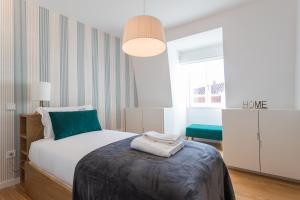 a small bedroom with a bed and a lamp at FLH Chiado Bright Apartment in Lisbon