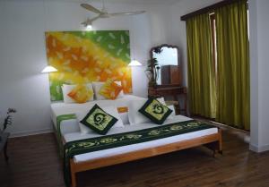 Muthu Nila villa- Mirissa في ميريسا: غرفة نوم عليها سرير ومخدات