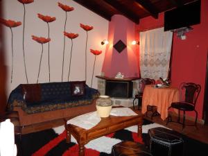 a living room with a couch and flowers on the wall at Mountain Ηouse in Arcadia in Vytina