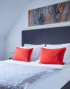 a bedroom with a bed with red pillows at B&B Park7 Wavre - Leuven in Huldenberg