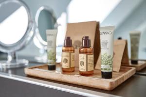 a shelf with four bottles of hair products on a counter at B&B Park7 Wavre - Leuven in Huldenberg