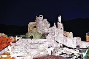 a large white castle is lit up at night at A casa da Igrexa in Ribadavia