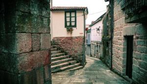a stone alley with stairs and a building at A casa da Igrexa in Ribadavia