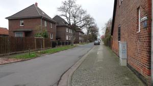 Une rue vide dans un quartier résidentiel avec des maisons dans l'établissement Laatzen - Private Apartment, à Hanovre