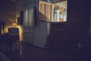 Cette chambre sombre dispose d'une fenêtre et d'une table avec une lampe. dans l'établissement Casa rural rincón de Letur, à Letur