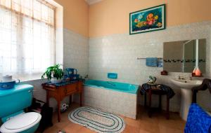 a bathroom with a blue tub and a sink at Petra's Country Guesthouse in Vryheid