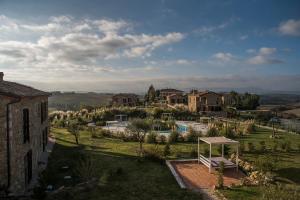 ヴォルテッラにあるTuscany Forever Premium Apartmentsの家とプールのある村の景色を望めます。