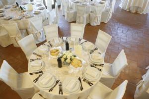 a table with white plates and utensils on it at Tenuta Su Vrau in Posada
