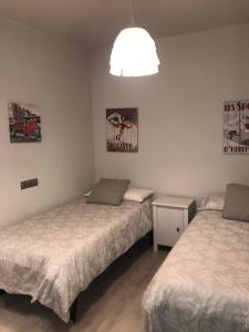 um quarto com 2 camas e uma luz em Apartamento Turístico Puigcerdá Correos em Puigcerdà
