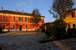 een groot oranje gebouw met een binnenplaats ervoor bij Agriturismo Corte Palazzo in Marcaria