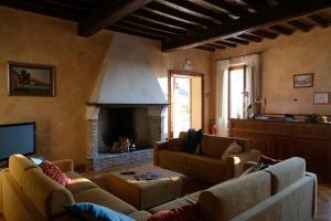 sala de estar con 2 sofás y chimenea en Agriturismo Corte Palazzo, en Marcaria