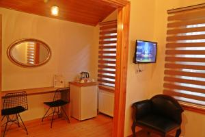 - un salon avec des chaises, une télévision et un miroir dans l'établissement Belizia Hotel, à Istanbul