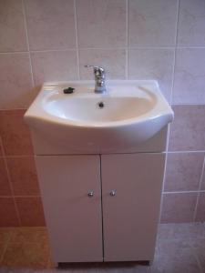 a bathroom with a sink and a white cabinet at Chatky v Českém ráji in Nemyčeves